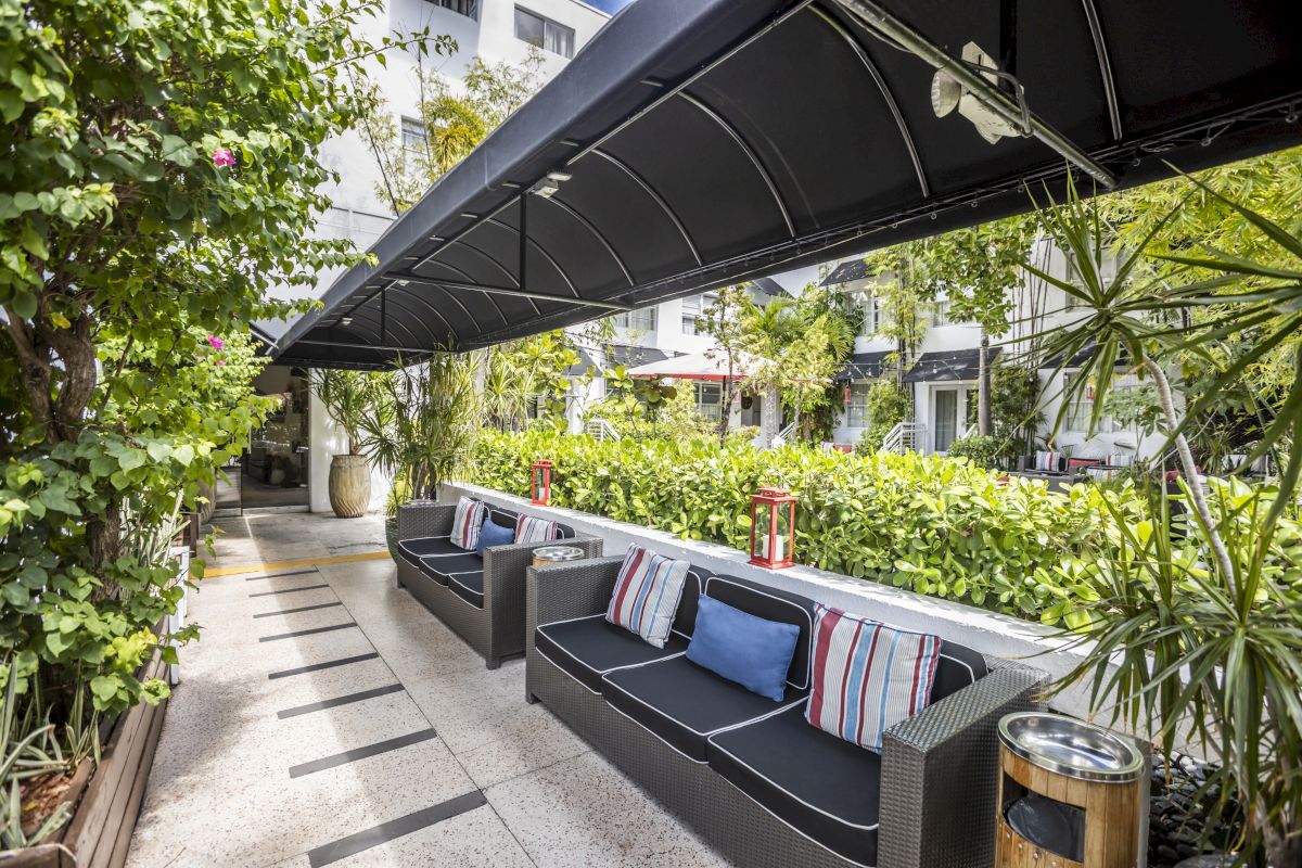 A covered outdoor seating area with a sofa and pillows.
