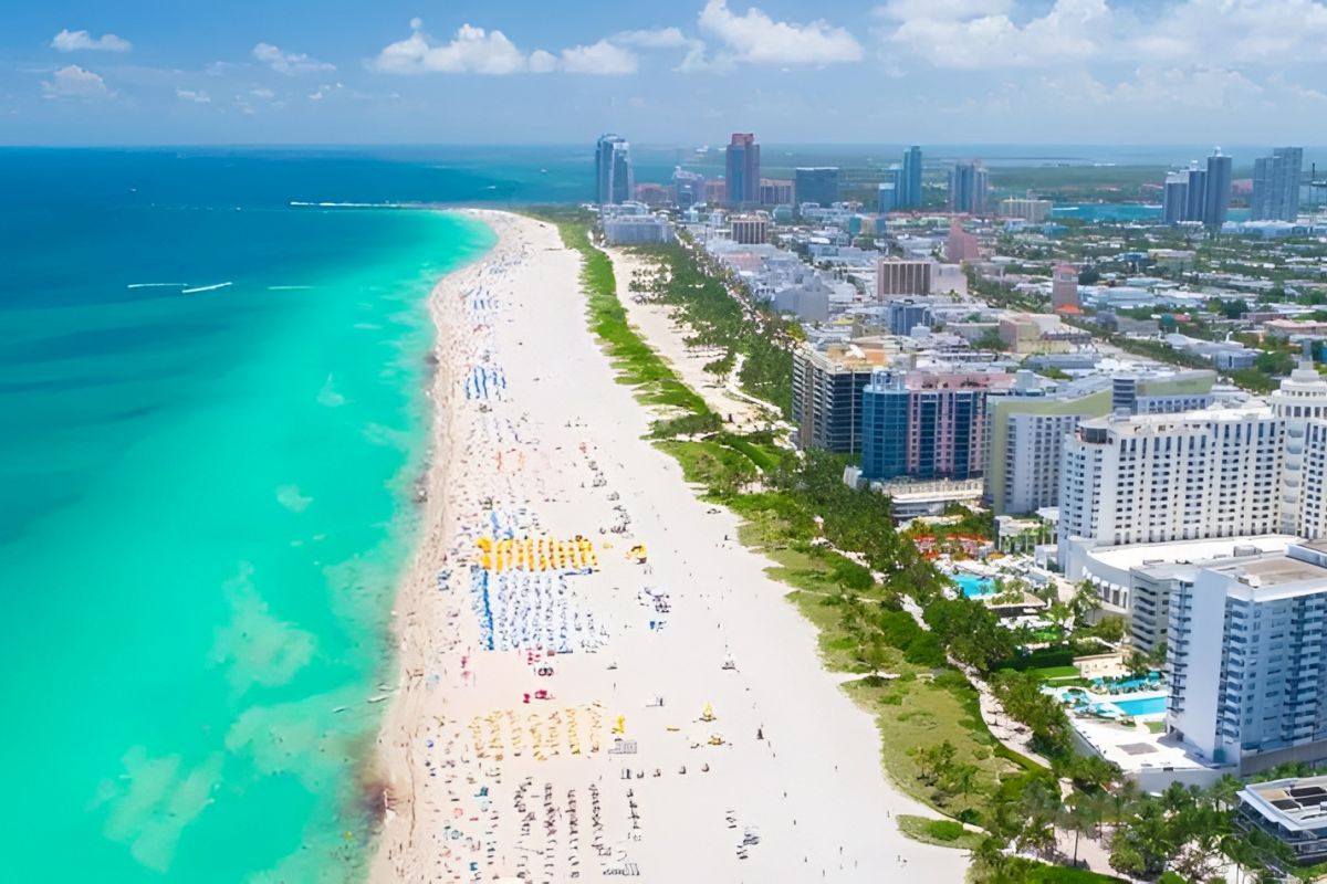 An aerial view of a beachside city with high-rise buildings and a vibrant beach.