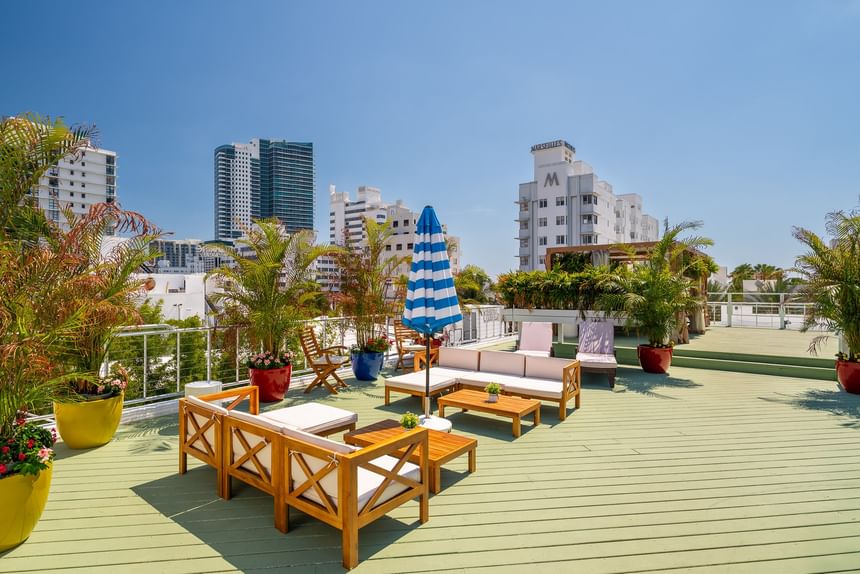 A rooftop deck with outdoor furniture and city view